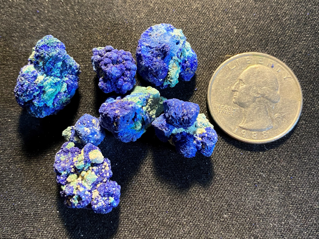 These Azurite nodules from Morocco exhibit typical copper oxidation. Each of the small Azurite crystal cluster parcels we offer weighs at least 10 grams.